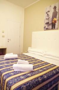 Hotel Vergilius في ريتشيوني: غرفة فندق عليها سرير وفوط