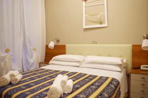 Hotel Vergilius في ريتشيوني: غرفة نوم عليها سرير وفوط