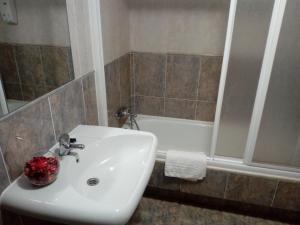 a bathroom with a sink and a shower and a tub at Apartamento Cefas in O Pedrouzo