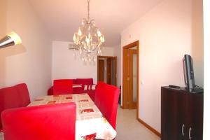 アルブフェイラにあるMagnifique appartement a 400 metre des plagesのダイニングルーム(テーブル、赤い椅子付)