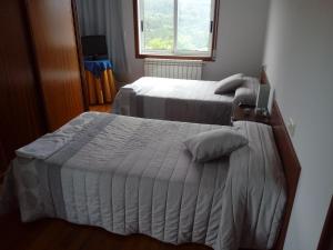 a bedroom with two beds and a window at Apartamento Cefas in O Pedrouzo