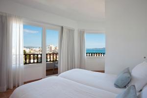 a white bedroom with a view of the ocean at Galaxia Boutique Hotel in Can Picafort