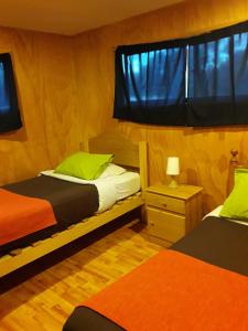 a bedroom with two beds and a window at La casa del Kori in Hanga Roa