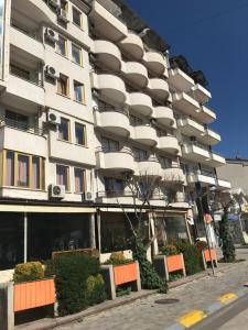 Un gran edificio blanco con sillas naranjas delante. en Baron Ohrid Makedonija, en Ohrid
