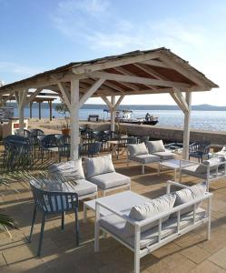 a group of white couches and chairs on the beach at Apartment Stipe in Maslenica