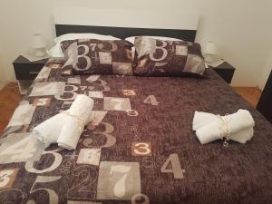 a bed with two pillows and a blanket with numbers on it at Apartment Stipe in Maslenica