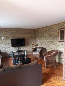 a living room with a couch and a stone wall at La casa del Kori in Hanga Roa