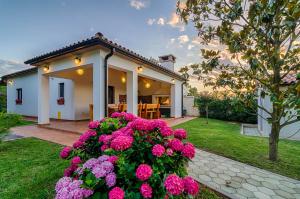 a house with pink flowers in front of it at Apartments Ana in Pula