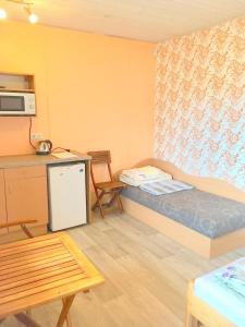 什文托伊的住宿－Poilsio namai "Undinė"，小房间设有一张床和一张桌子