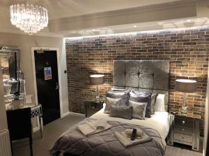 a bedroom with a large bed with a brick wall at The Wolf Inn in Lowestoft