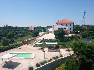 una pequeña piscina en un patio junto a una casa en Quinta Quatro Ventos en Sertã