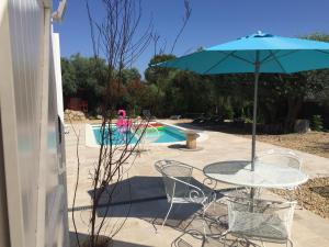 einen Tisch mit einem Sonnenschirm neben einem Pool in der Unterkunft les Chambres d'Amis in Sanary-sur-Mer