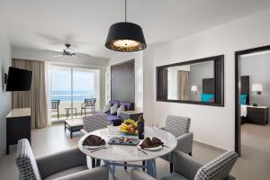 sala de estar con mesa y sillas en Ventus at Marina El Cid Spa & Beach Resort - All Inclusive, en Puerto Morelos