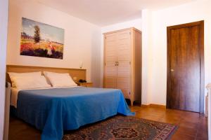 a bedroom with a bed with a blue blanket at Corallo Country House in Noci +46 photos