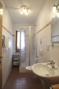 een witte badkamer met een douche en een wastafel bij Ferienwohnung Bickel in Absberg