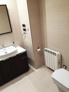 a bathroom with a sink and a toilet and a mirror at ESTUDIO MODERNO CENTRO-PLAYA GIJÓN in Gijón