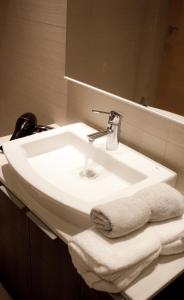 a bathroom sink with a towel and a mirror at ESTUDIO MODERNO CENTRO-PLAYA GIJÓN in Gijón