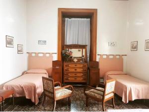 利帕里的住宿－阿爾瓦特羅斯住宿加早餐旅館，一间设有两张床、两把椅子和一个梳妆台的房间