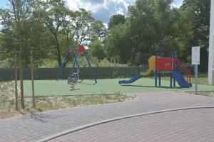 einen Spielplatz mit zwei Spielgeräten in einem Park in der Unterkunft Apartament Berlin in Świnoujście