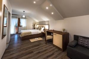 a hotel room with a bed and a desk and a couch at Guest House Vana in Korenica +8 photos