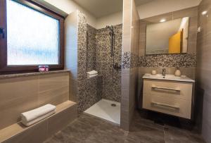 La salle de bains est pourvue d'un lavabo et d'une douche. dans l'établissement Guest House Vana, à Korenica