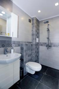 a bathroom with a toilet and a sink and a shower at Lovely Sunrise - първа линия морска градина in Burgas City
