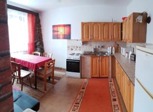 uma cozinha com armários de madeira e uma mesa com uma toalha de mesa vermelha em Apartment Janka Demanova em Liptovský Mikuláš