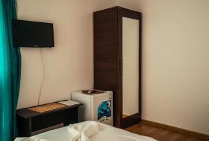 a room with a bed and a refrigerator and a mirror at Vila Aty & Michelle in Vama Veche