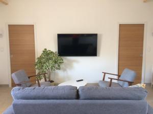 a living room with a couch and two chairs and a tv at La grange in Machecoul