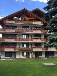 ein Gebäude mit Balkonen und roten Blumen darauf in der Unterkunft St Martin Apartments in Täsch