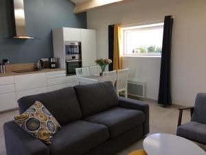 a living room with a couch and a kitchen at La grange in Machecoul