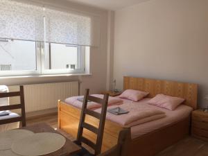 グディニャにあるWilla Przy Plaży Gdynia Kamienna Góraのベッドルーム1室(ピンクの枕が付くベッド2台、窓付)