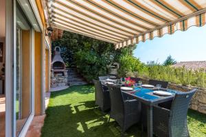 un patio con mesa y sillas bajo una pérgola en Sleep In Biot, en Biot