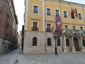 a building on a street with flags on it at Tirwal Suite in Teruel