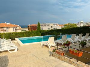 a group of chairs sitting next to a swimming pool at Villa Iztok in Sozopol