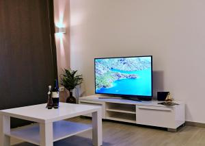 a television sitting on a white stand with a table at Apartment Luce in Njivice