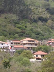 eine Gruppe von Häusern an der Seite eines Hügels in der Unterkunft Danny's Rural Suite in Curral das Freiras