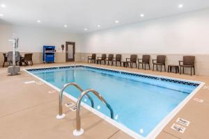 a pool in a room with chairs and tables at Sleep Inn & Suites in South Jacksonville