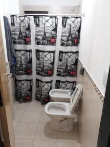 ein Badezimmer mit 2 WCs und einem Duschvorhang in der Unterkunft Departamento en Carlos Paz para familias in Villa Carlos Paz