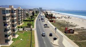 una vista de una playa con coches conduciendo por una carretera en Cabañas 4 Esquinas, en La Serena