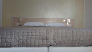 a bedroom with a large bed with two pillows at Gli Angeli in Loreto