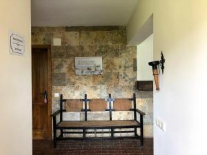 un banc dans une pièce avec un mur en pierre dans l'établissement Villa Mavi, à Maello
