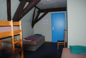 een kamer met 2 stapelbedden en een blauwe deur bij Charlie Rockets Youth Hostel in Brugge