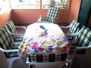 a table with a flowered table cloth on it with chairs at Apartment Relax in Fažana