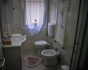 a bathroom with a toilet and a sink and a window at Valsugana in Mestre