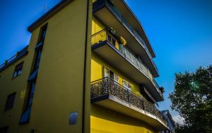 a yellow building with a balcony with flowers on it at Valsugana in Mestre