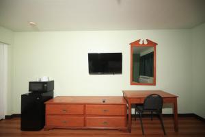 a room with a desk and a mirror and a dresser at Texas Inn Waxahachie in Waxahachie
