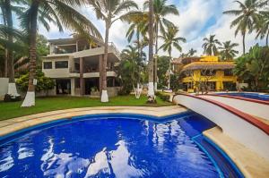 a pool in front of a house with palm trees at Casa Lucas in Sayulita