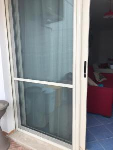 a sliding glass door with a window in a room at Villa Azzurra in Marina di Pescoluse