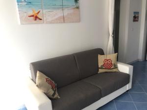 un divano in soggiorno con una foto di una spiaggia di Villa Azzurra a Marina di Pescoluse